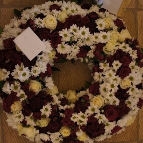 Begravelseskrans med bordeaux roser og hvide blomster