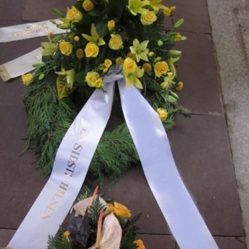 Begravelseskrans med hvide blomster, grønt og hvidt bånd