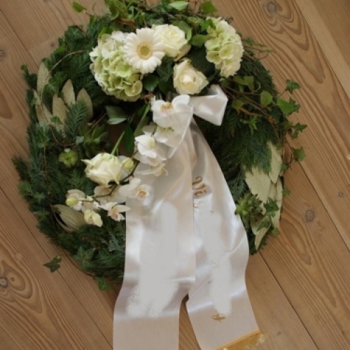 Begravelseskrans med røde roser og gule og hvide blomster