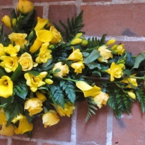 Bårebuket i gule nuancer med roser, calla og grønne bregner