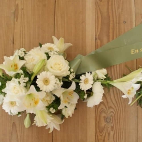 Bårebuket med hvide blomster og grønt bånd med teksten En sidste hilsen