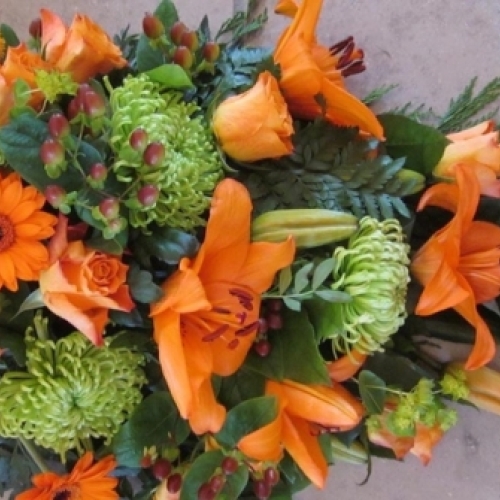 Bårebuket med orange liljer, roser og grønne blomster