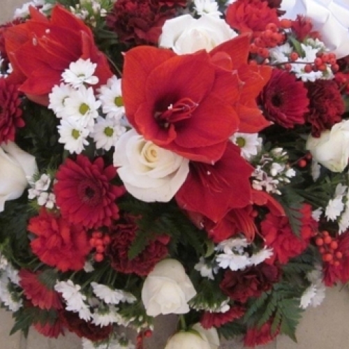 Begravelsesdekoration med rød amaryllis, hvide roser og røde blomster