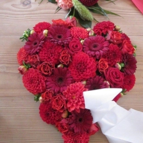 Blomsterhjerte med røde roser og røde blomster